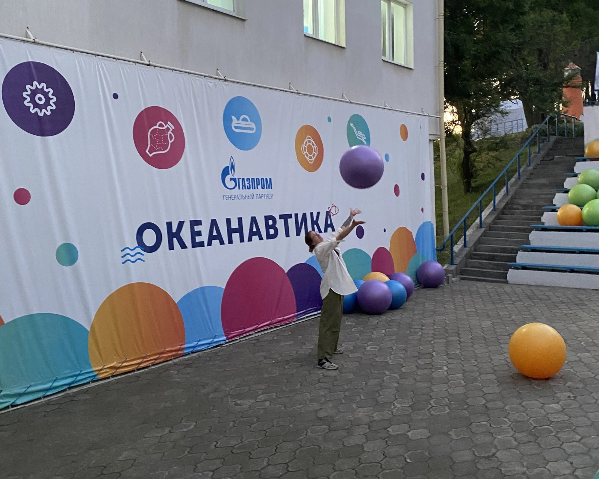 Viktoryia lance un ballon devant la bannière Oceanautica, au camp